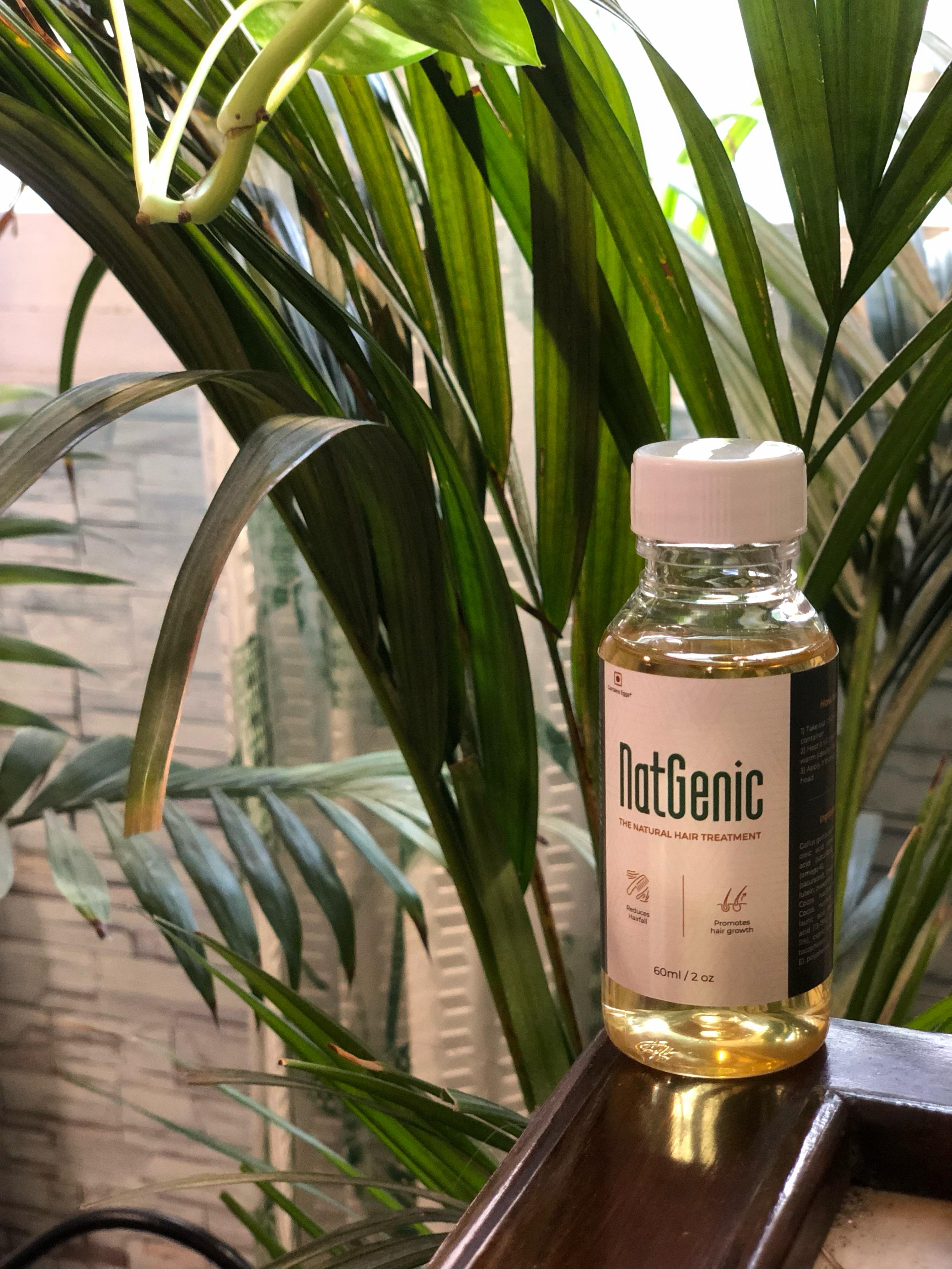 Natgenic natural hair oil bottle among green leaves